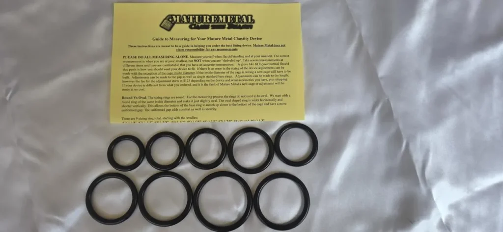Mature Metal plastic sizing ring kit: nine black rings from 1 1/8 inch to 2 1/8 inch beside the printed measuring instruction sheet.