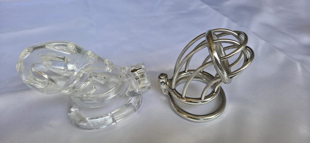 Clear plastic chastity cage beside a stainless steel open bar chastity cage.