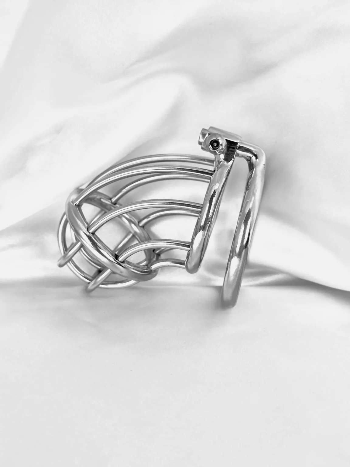 Stainless steel chastity cage laid flat, off the body