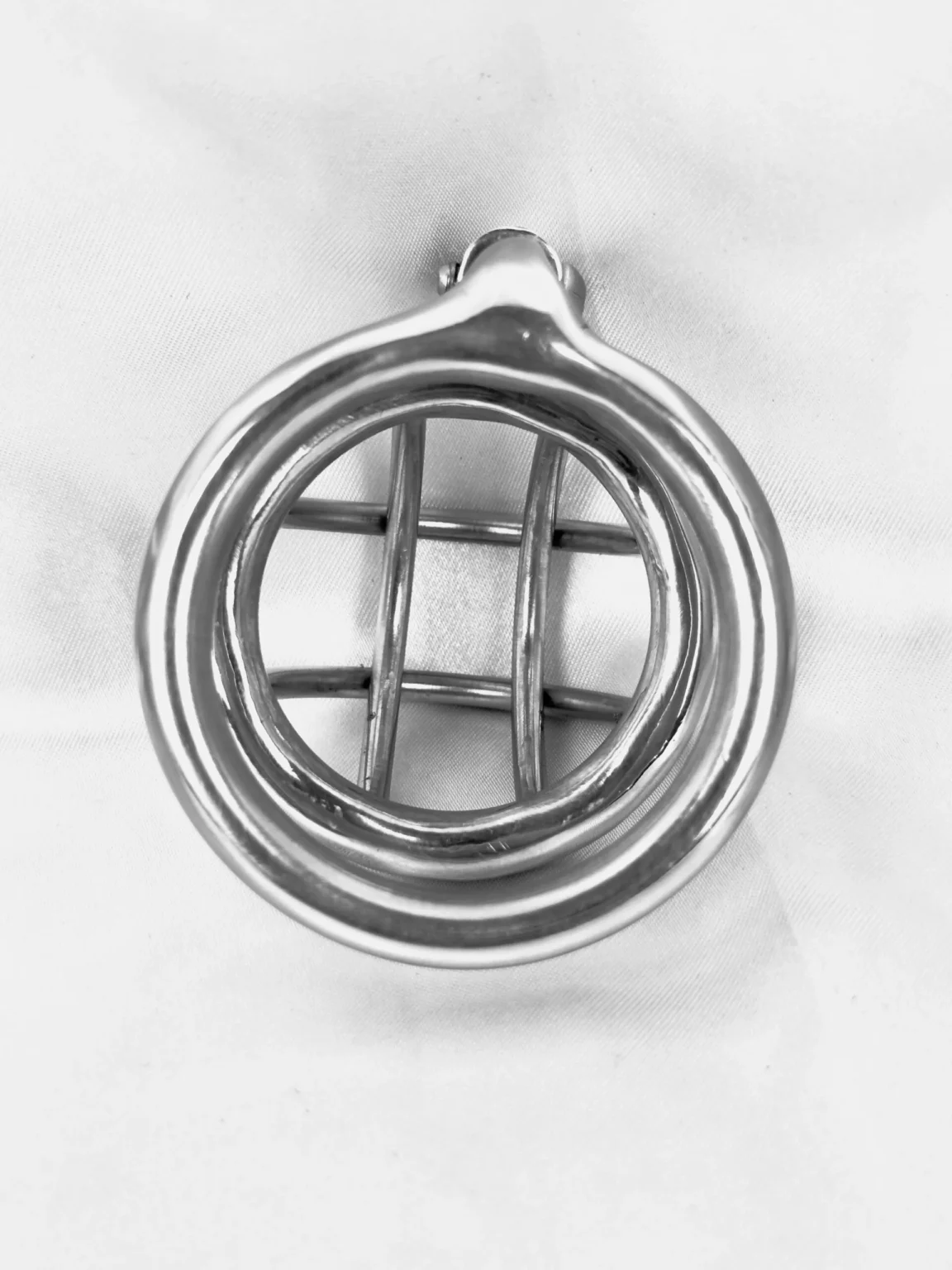 Front view of an open bar stainless steel chastity cage showing the open lattice at the tip