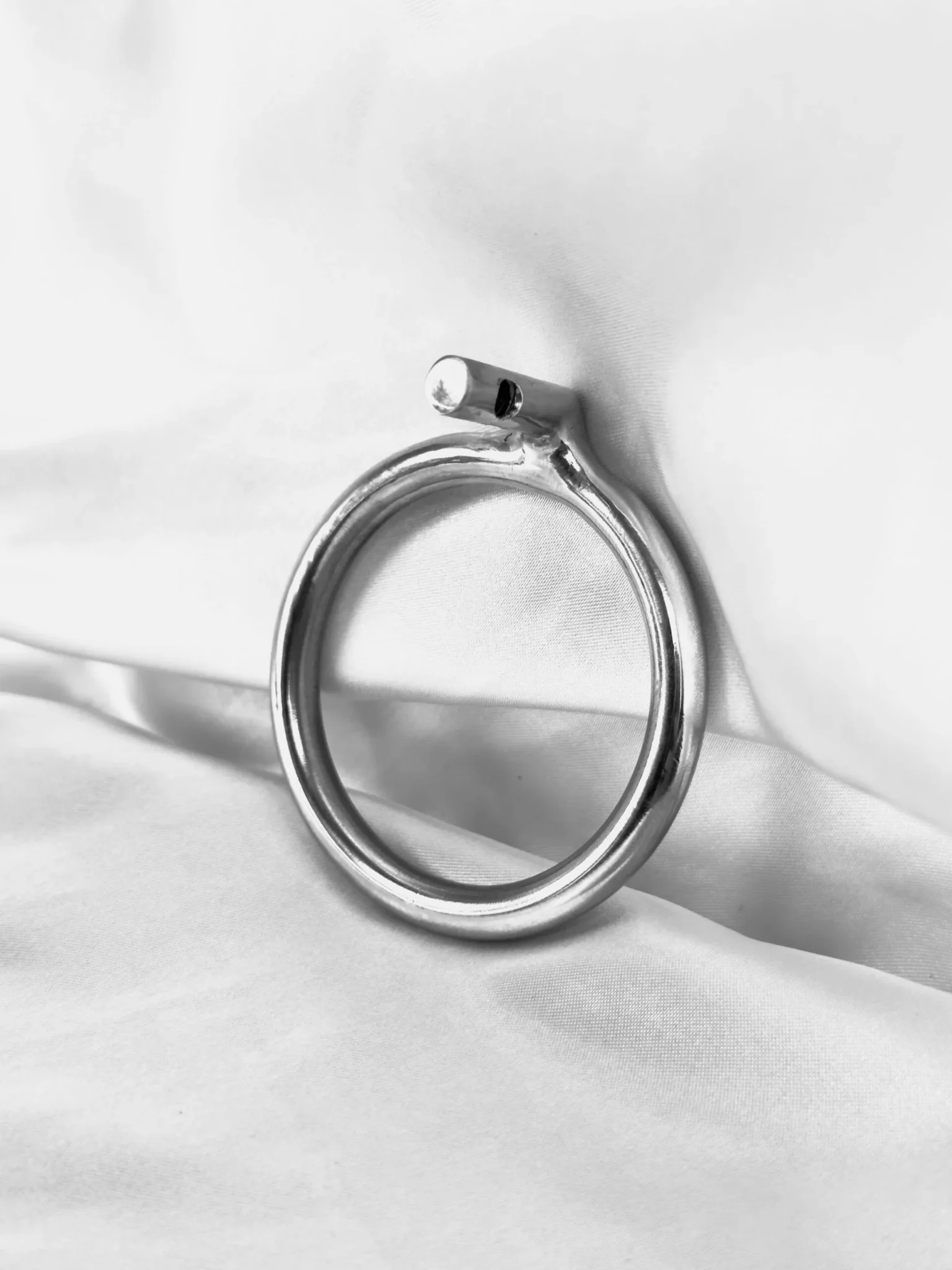 A round stainless steel chastity base ring